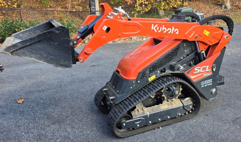 Kubota SCL 1000 mini skid track loader with bucket attachment, used by Calvert Specialty Contracting